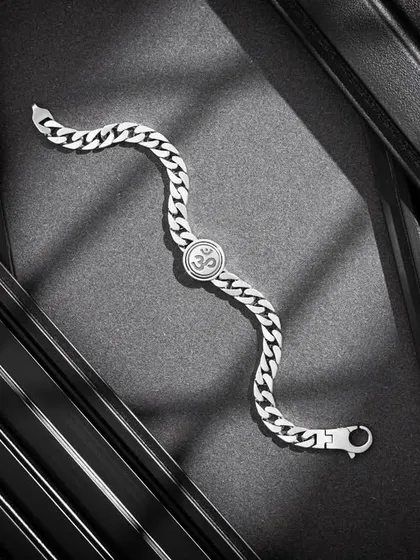 A dramatic shot of a men's silver bracelet with an Om symbol. We used textured black panels and directional lighting to create striking shadows and depth, giving the jewellery a bold and modern feel.