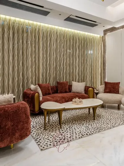 A closer look at the plush velvet seating arrangement. The dalmatian-print rug adds a playful yet sophisticated touch, while the floor-to-ceiling curtains with ambient backlighting create a dramatic and warm effect.