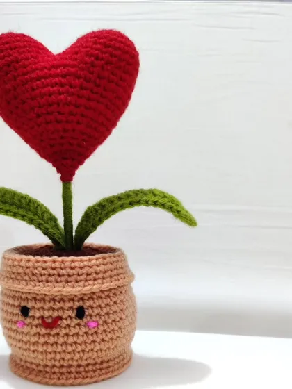 A simple, clear photo of the red heart pot against a white background, highlighting its vibrant color and cheerful expression.