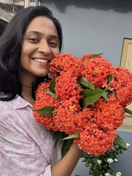 A bright smile and a bouquet of beautiful red flowers.