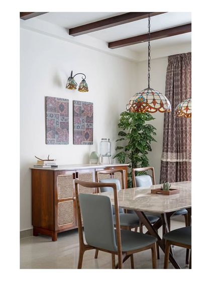 A closer view of the dining console and stained-glass lights. These elements add color and an old-world charm, complementing the modern dining set and wooden ceiling rafters.
