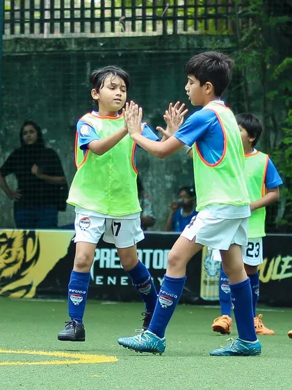 A moment of sportsmanship and teamwork as two young players high-five during a game.