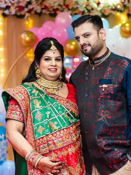 A formal portrait of the traditionally dressed couple at their baby shower celebration.