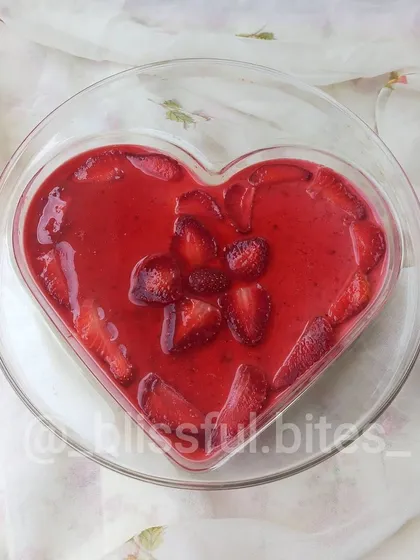 A larger, heart shaped Strawberry Cheesecake, perfect for sharing with a loved one. The top is decorated with beautifully arranged fresh strawberries.