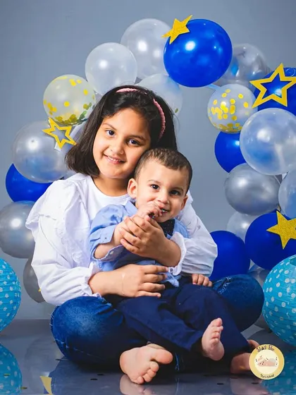 A sweet embrace between a sister and her baby brother during a birthday setup. Our sessions always make time to include important family members.