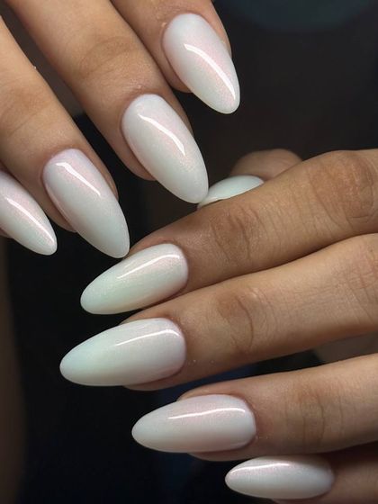 A stunning, pearlescent white on long, almond-shaped extensions. The iridescent finish gives these nails an ethereal, almost magical glow.