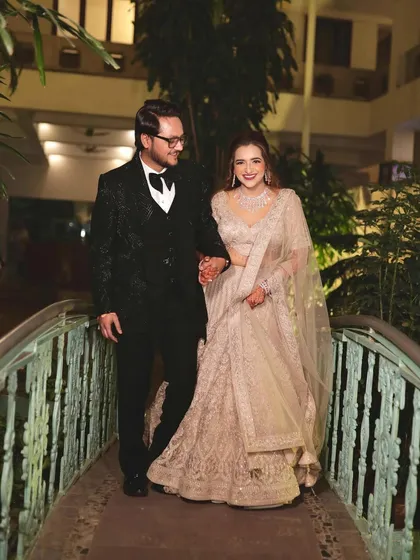 A beautiful couple shot from their reception. The bride looks elegant in her beige lehenga with soft makeup and hair.