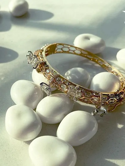 This captivating bracelet with its honeycomb gold pattern and diamond charms encircles your wrist, adding a subtle elegance to any outfit.