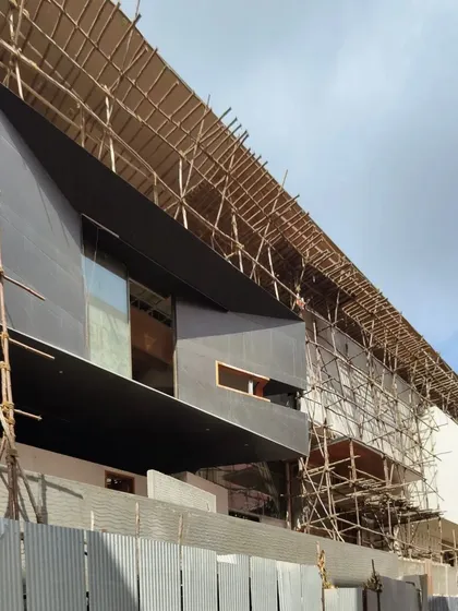 A duplicate of the previous construction photo, this view of the 'House of Reddys' site showcases the raw structure and the beginning of the facade installation, revealing the layers of the building's skin.