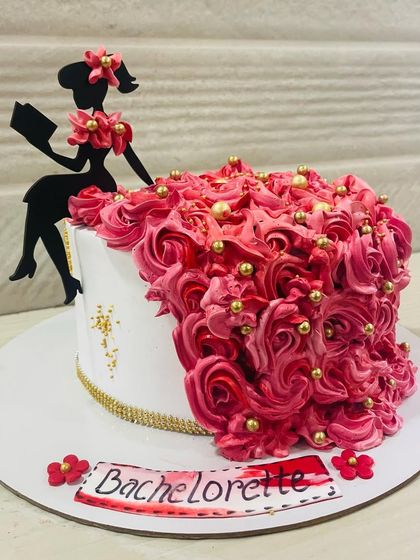 A gorgeous bachelorette cake featuring a silhouette of a lady whose dress is made of a cascade of pink buttercream roses.