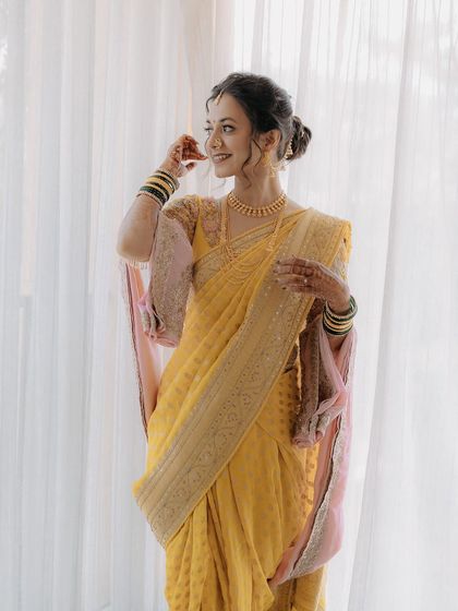 A full-length portrait of the bride in her beautiful yellow saree, looking ethereal and elegant.