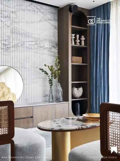 A shot from the feature showcasing the custom TV unit and shelving, blending wood, marble, and soft blue curtains.