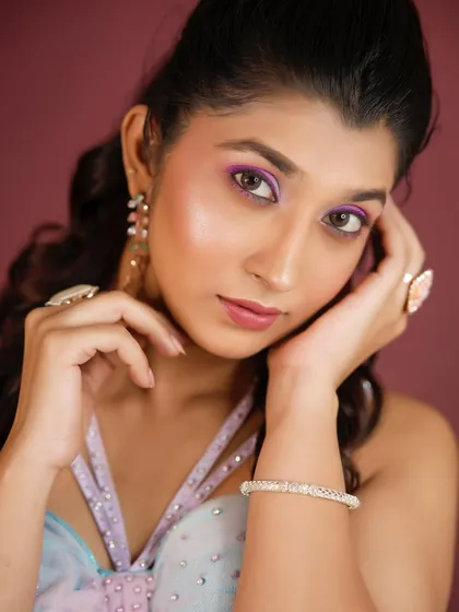 A close-up portrait highlighting the details of the eye makeup and accessories.
