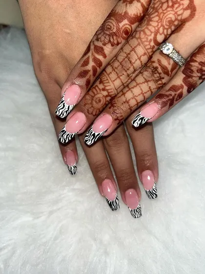 A fun take on the French manicure. These coffin-shaped nails feature a classic nude base with trendy zebra-print tips.