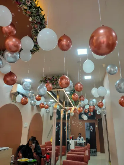 A wide shot of the salon's interior, showing how the hanging balloons create a festive and upscale atmosphere for clients. This is a popular choice for salon anniversaries and festive offers.