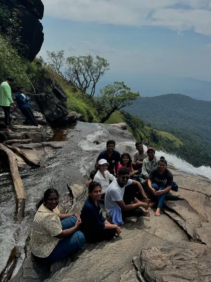 Our group relaxing on the rocks at the top of Bandaje falls, with the water flowing beside them.
