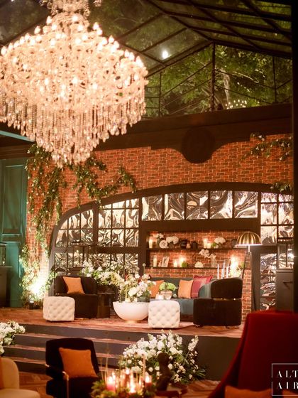Another view of the lounge area in the glass house, showing the interplay of crystal chandeliers, brick walls, and lush greenery. The design was all about laid-back luxury with an uber-cool vibe.
