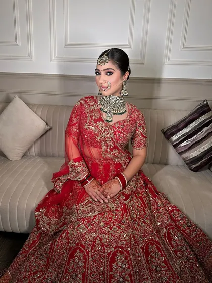 A full-length view of the bride, looking absolutely stunning in her red lehenga and heavy jewellery.