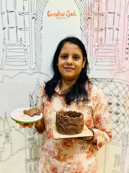 A proud student displays the intricate coiled pot she created in my pottery workshop, a perfect example of what you can make with hand-building techniques.