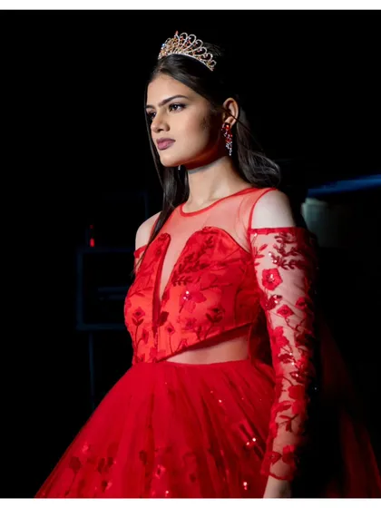 Our fashion event coverage focuses on capturing the elegance and emotion of the moment. Here, a model at a fashion show is seen in a breathtaking red tulle gown, her poised expression caught in a candid moment backstage. We aim to tell a story that goes beyond just the clothes on the ramp.