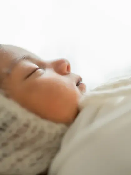 A beautiful profile shot, highlighting the baby's delicate features against a soft, bright background.