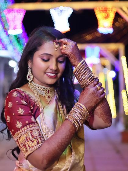 A beautiful shot of the bride under festive lights. The makeup has a subtle glow that catches the light perfectly.