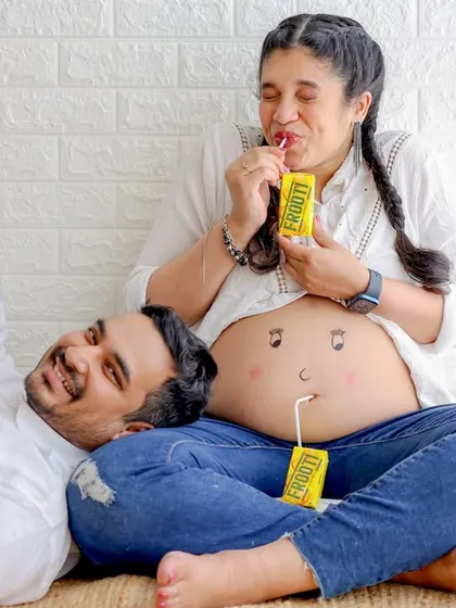 Maternity shoots can be fun and playful too. We love capturing candid moments like this, where the couple shares a lighthearted moment, creating authentic memories of their pregnancy journey.