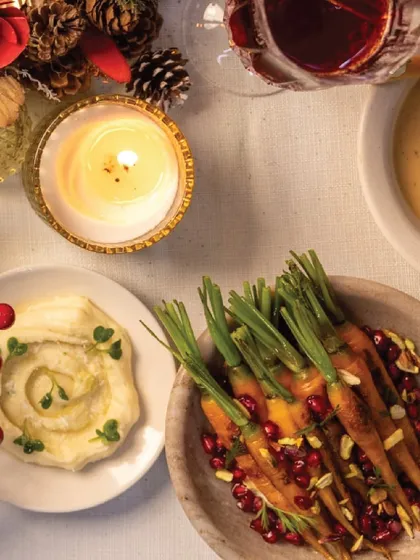 A cozy, candlelit shot of our creamy hummus and roasted carrots, perfect side dishes for a warm holiday gathering.