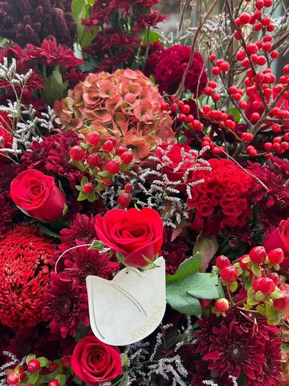 A closer look at this passionate red arrangement. The mix of roses, chrysanthemums, and hypericum berries creates a rich tapestry of colour and texture, perfect for expressing love.