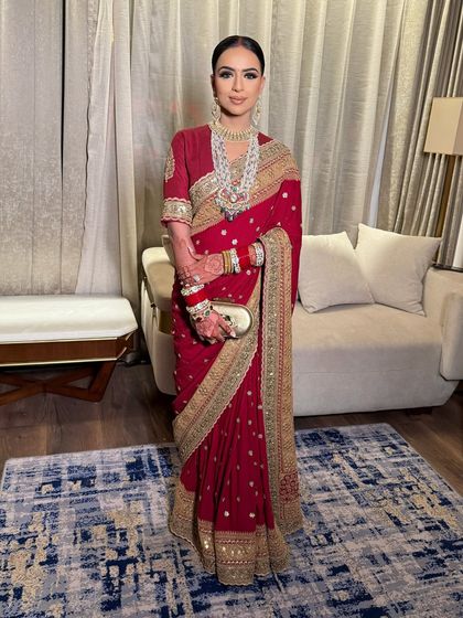 The complete look, showcasing the beautiful drape of the saree and the stunning bridal jewelry. The makeup enhances her features without overpowering the traditional elegance.