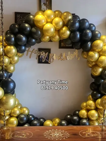 A simple but elegant black and gold circular balloon arch around a traditional Indian swing (jhoola). This is a great way to decorate for a party at home.