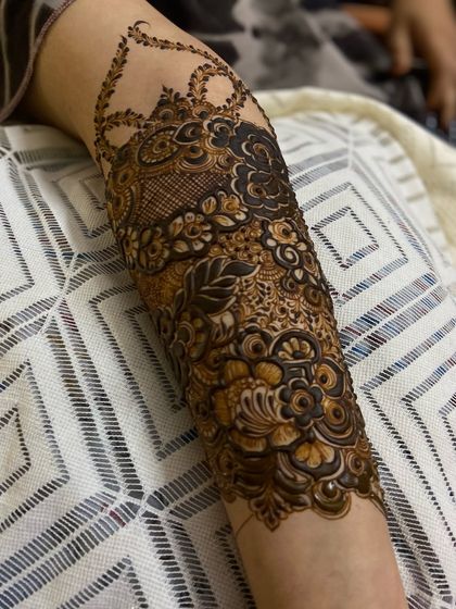 An angled view of the forearm, highlighting the shading and layering techniques used to create depth and dimension in the henna design.