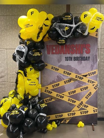 The complete Fear Factor themed backdrop for Vedanshi's 10th birthday. The custom-printed balloons and caution tape create a thrilling and unique party entrance.