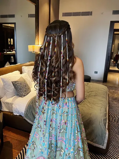 A full view of the half-up hairstyle with beaded strands, showing how it adds a playful and colorful element to the overall look.