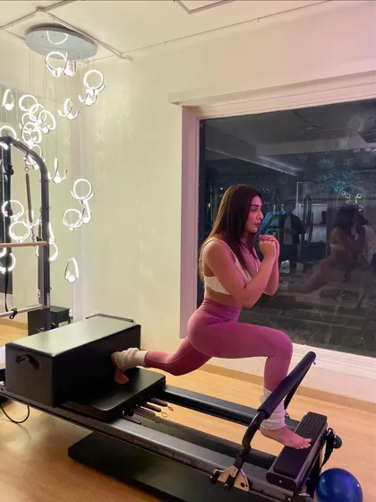 She came for the core burn and stayed for the vibe. A reformer lunge is a killer move for leg strength and stability.