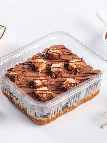For the ultimate candy bar lover, our Snickers-inspired dessert tub. This indulgent treat has layers of chocolate cake, caramel, and peanuts, topped with chunks of Snickers and a chocolate drizzle.