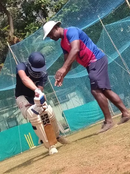 Here I am working with a batsman on his technique. Correcting small details in the stance and swing can make a huge difference in a player's game.