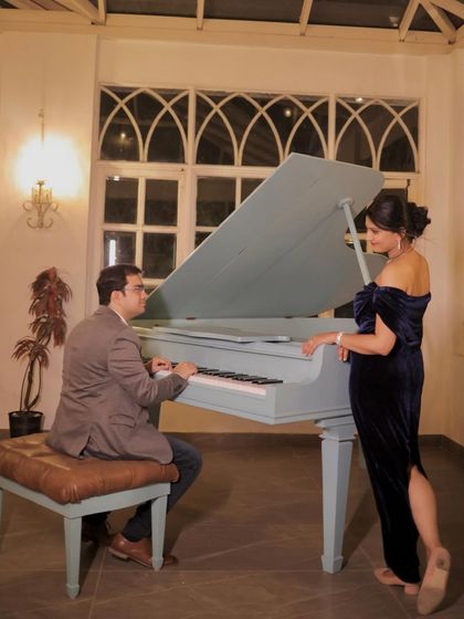 An elegant evening look by the piano. The makeup is sophisticated and glamorous, with a focus on her eyes.