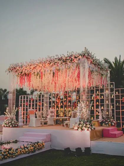 This quintessential mandap at Radisson Karjat features a stunning ceiling of hanging wisteria and a candle wall backdrop. The design combines classic elegance with modern romance for a truly timeless look.