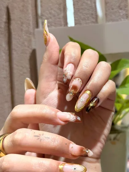 A side view highlighting the length and elegant almond shape of these custom-painted nail extensions.