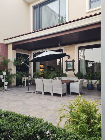 This backyard patio is the perfect blend of classic farmhouse warmth and serene outdoor living. The covered dining area provides a seamless transition from the interior to the garden.