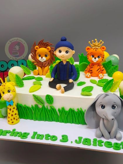 "Roaring into 3!" A fun jungle-themed cake with a custom boy figurine and his favorite safari animals.