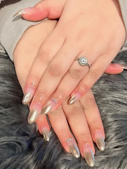 A stunning silver chrome effect on long stiletto nails, with delicate silver bow charms for an extra feminine touch.