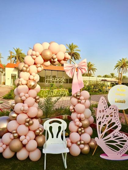 A closer view of the butterfly-themed birthday, focusing on the neon sign, the large butterfly cutout, and the elegant balloon arch.