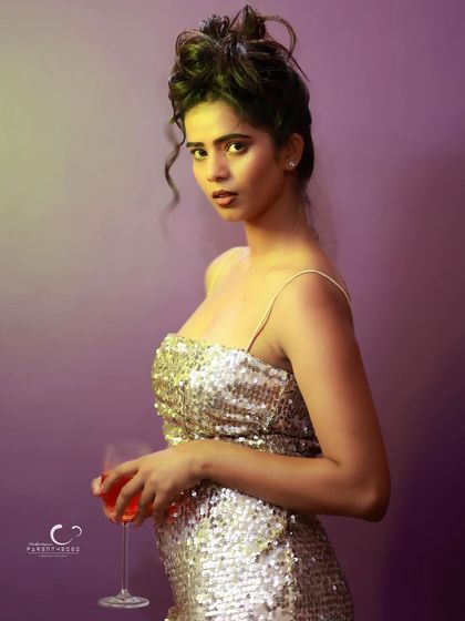 A confident and engaging portrait. Her direct gaze and the wine glass prop create a sense of narrative and character.