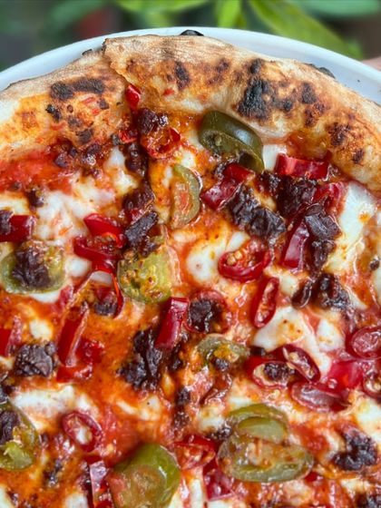 A close-up on the heat. The combination of red chilies and jalapeños makes this pizza a true spice seeker's dream.