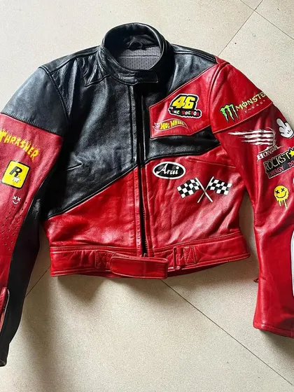I thrifted this jacket and gave it a complete makeover. It's a custom hand-painted biker jacket with a red, black, and white colorway, covered in patches inspired by biker culture, from Monster Energy to a dripping smiley face.