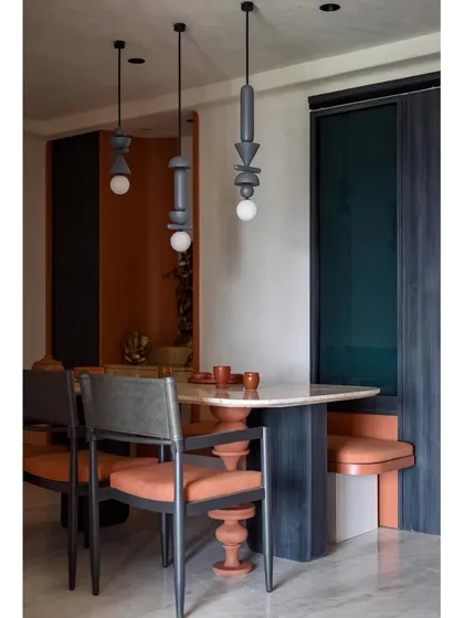 The full dining setup, with the custom table, chairs, and suspended lights. The space is a perfect blend of traditional craftsmanship and modern design.