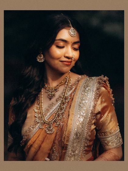 A classic bridal portrait with a focus on the stunning traditional jewelry. The warm, soft lighting creates a timeless and graceful image.