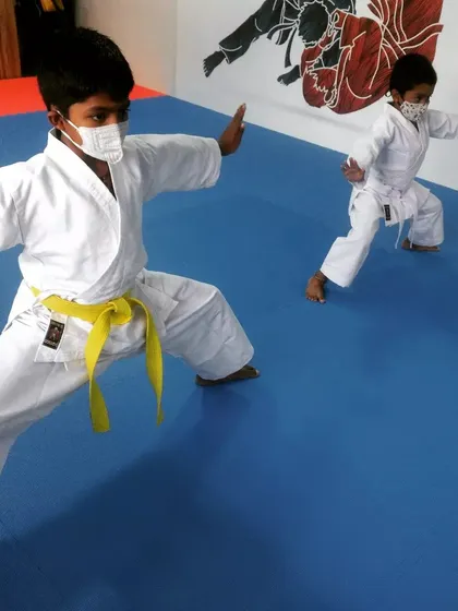 Focus and discipline start early. Here, two of our youngest students practice a fundamental karate stance, building a strong foundation in Kenyu Ryu Karate. Our kids' classes are designed to be engaging while teaching core martial arts principles.